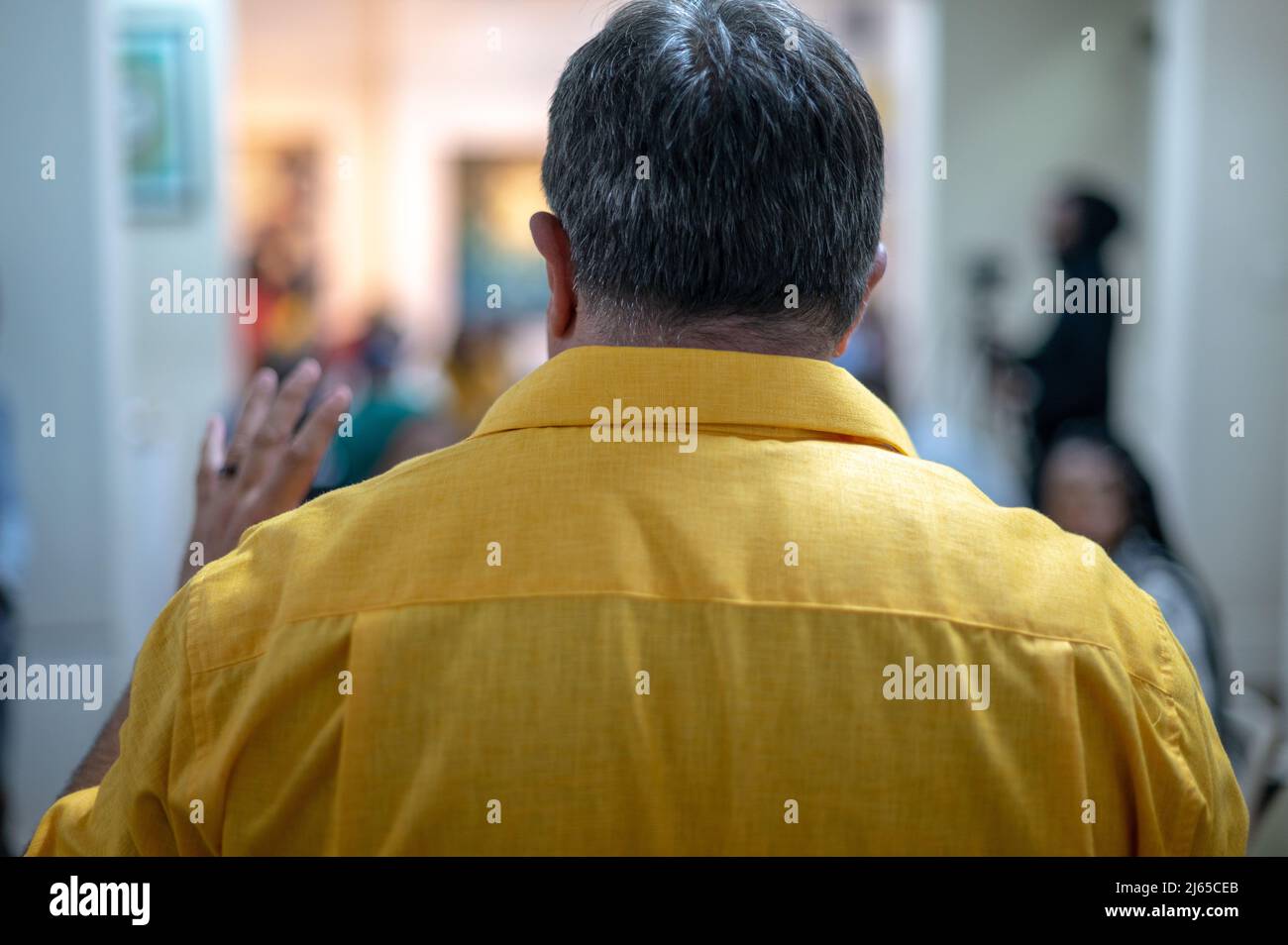 Rear view of man talking to group of people Stock Photo - Alamy