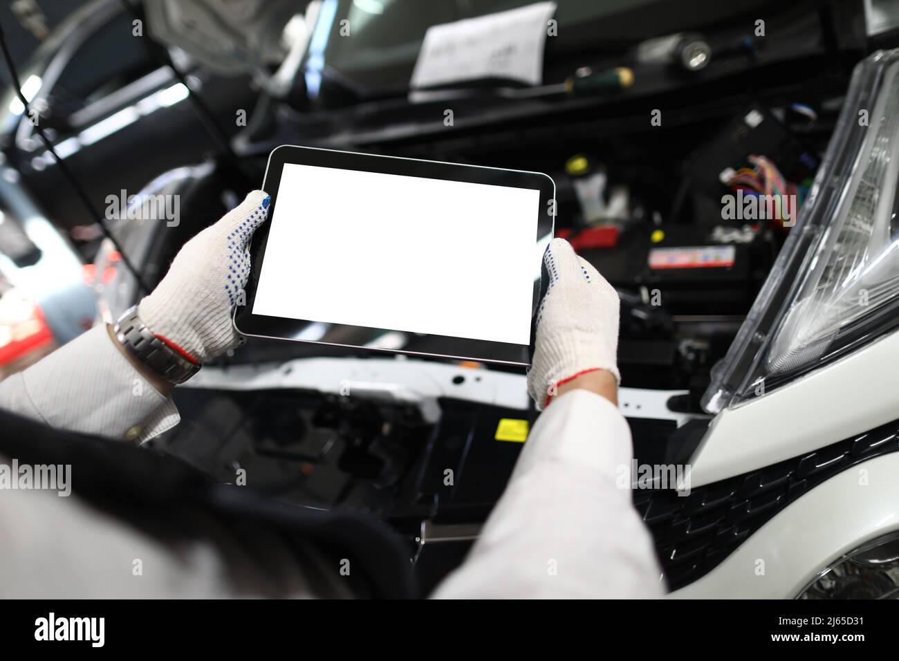 Mechanic worker using tablet for diagnostics of technical condition of vehicle Stock Photo