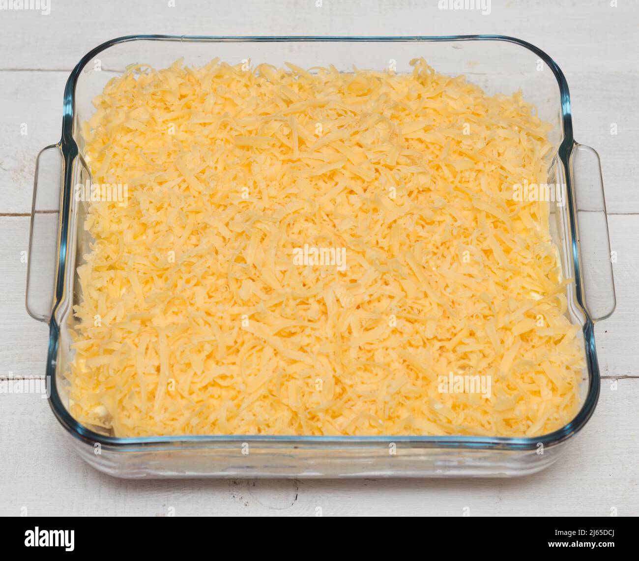 Top view of uncooked lasagna in transparent tray on a wooden table Stock Photo
