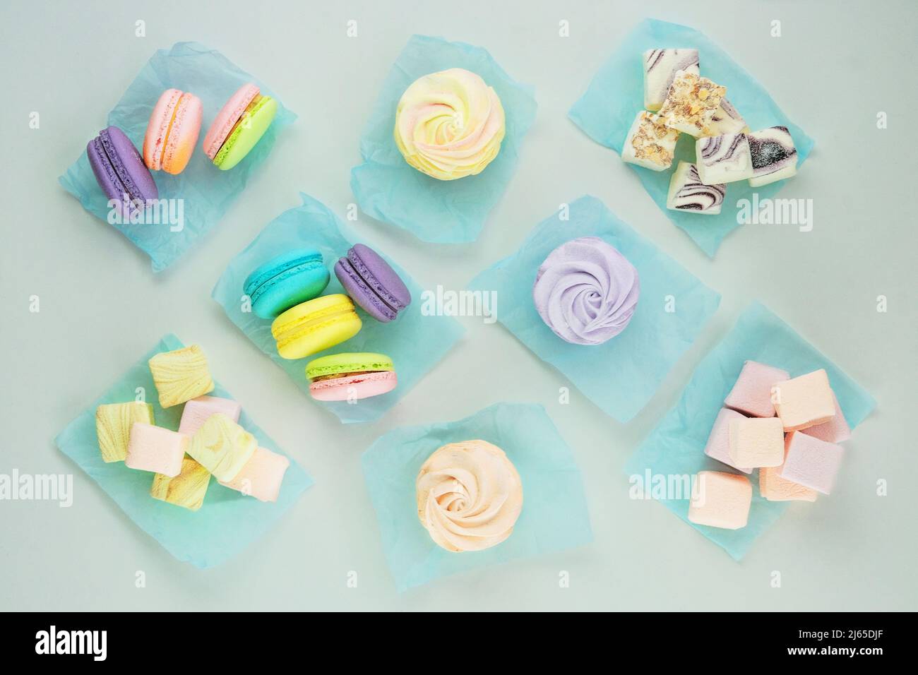 Assortment of desserts: macaroons, marshmallows and zephyrs, closeup. Traditional colored sweet desserts for the holiday. Top view. Stock Photo