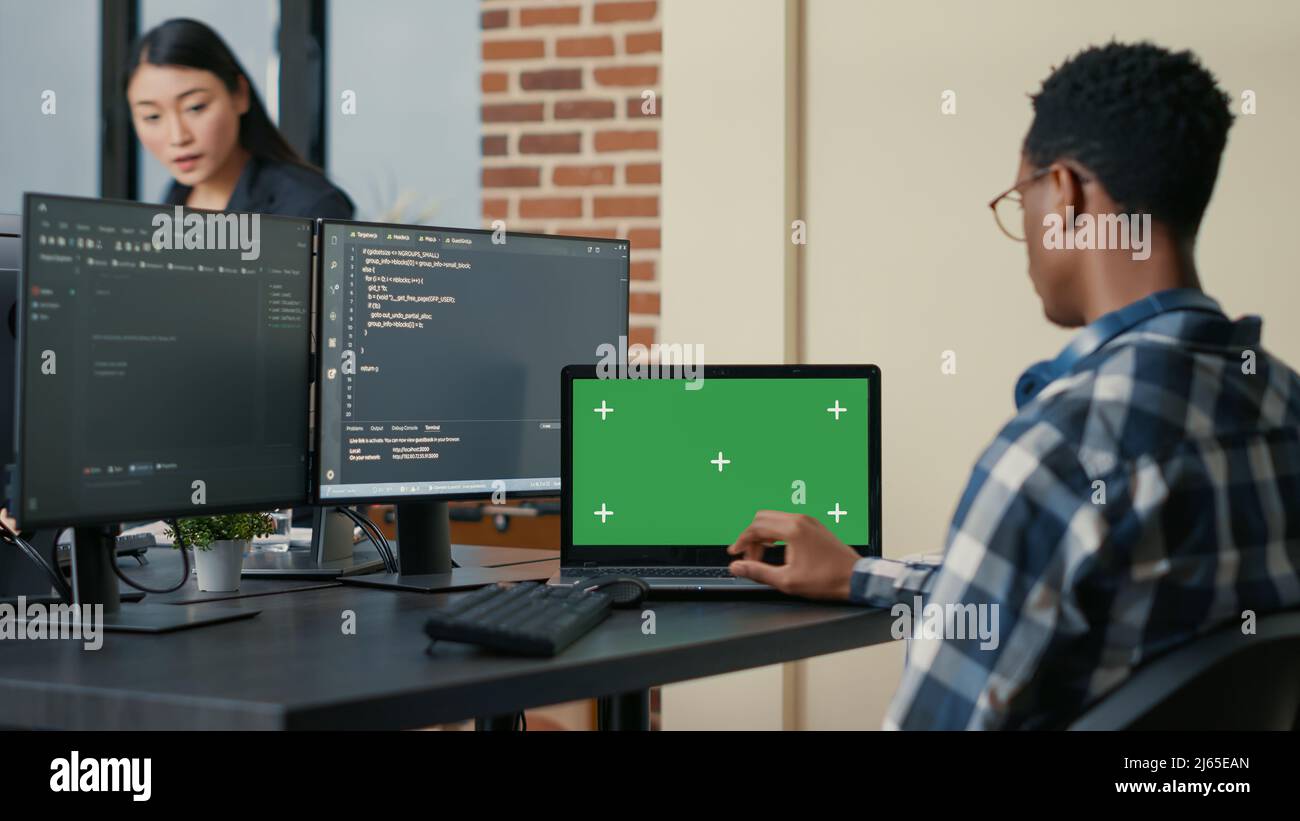 Database designer writing code using laptop with green screen chroma ...