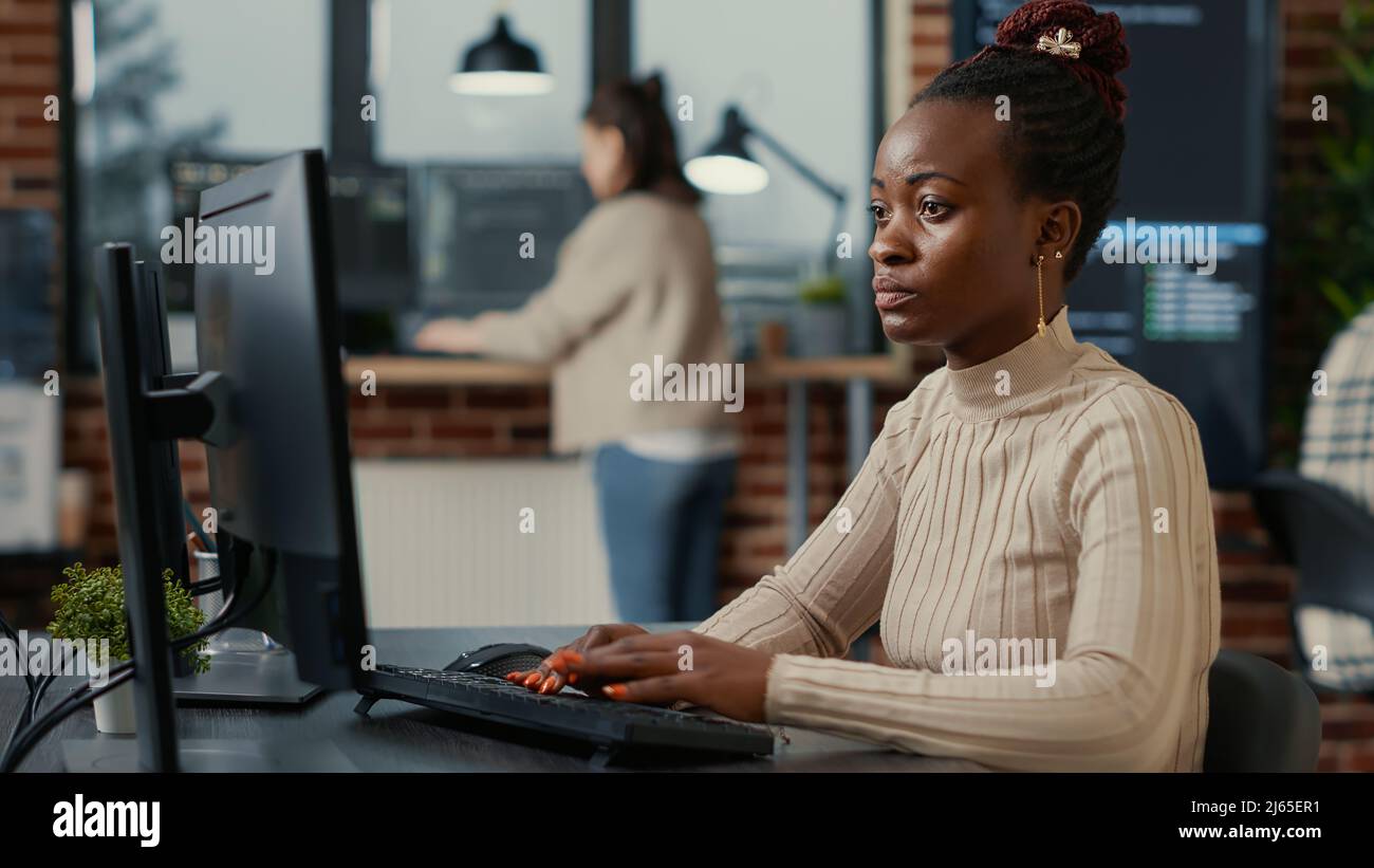 African american software engineer working focused looking at computer ...
