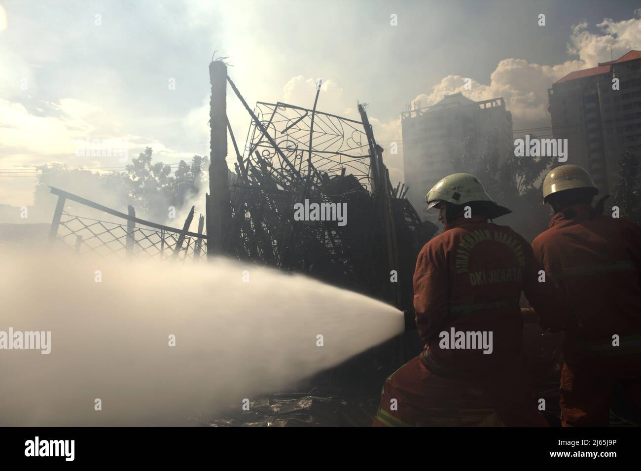 Members of Jakarta firefighting squad performing the cooling phase after a fire accident burned down storage buildings of a home industry in Kebayoran Lama, South Jakarta, Jakarta, Indonesia. Stock Photo