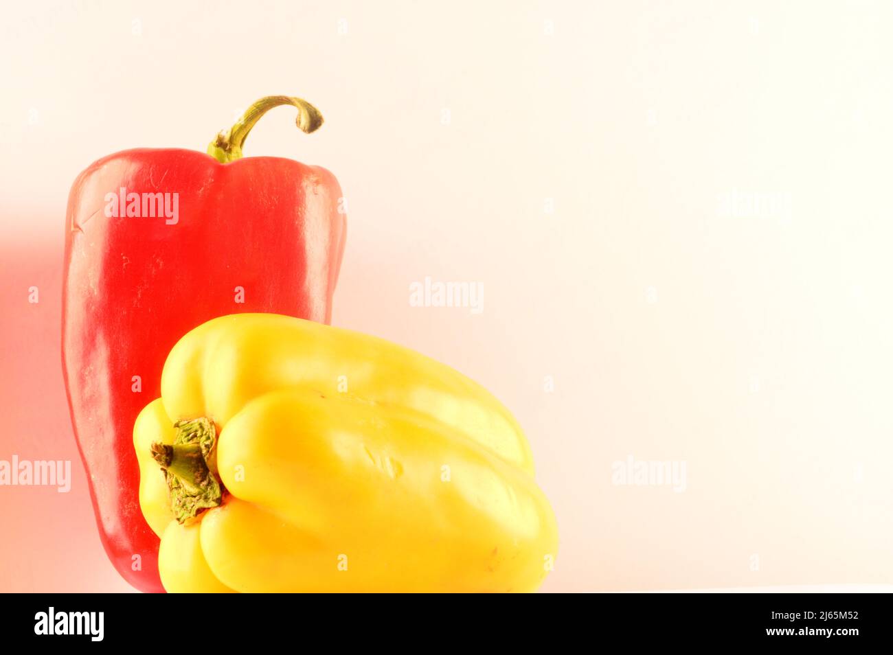 Red and yellow pepper on white background Stock Photo - Alamy