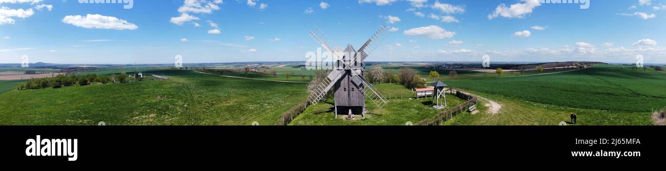 A drone flight of a historic wooden windmill in a panoramic view Stock Photo