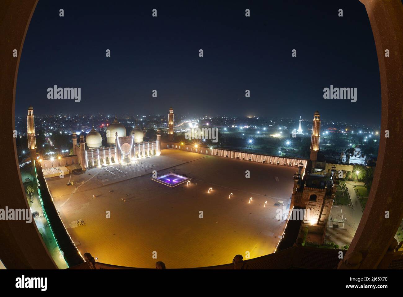 An attractive splendid stunning aerial view of historical Mughal Era Badshahi mosque decorated with lights to mark the holy night and seek divine blessings of Lailatul Qadr, also known as the Night of Power in Lahore. Laylat ul Qadr or commonly known as Shab-e-Qadr, the ‘Night of Power' is full of blessings because the eminent Quran descended in it, Muslim worshipers arrive to offer evening prayers 27th night of the Holy month of Ramadan at an illuminated Badshahi Mosque' according to tradition, when the Muslim holy book, the Koran, was revealed to the Prophet Mohammed through the angel Gabrie Stock Photo