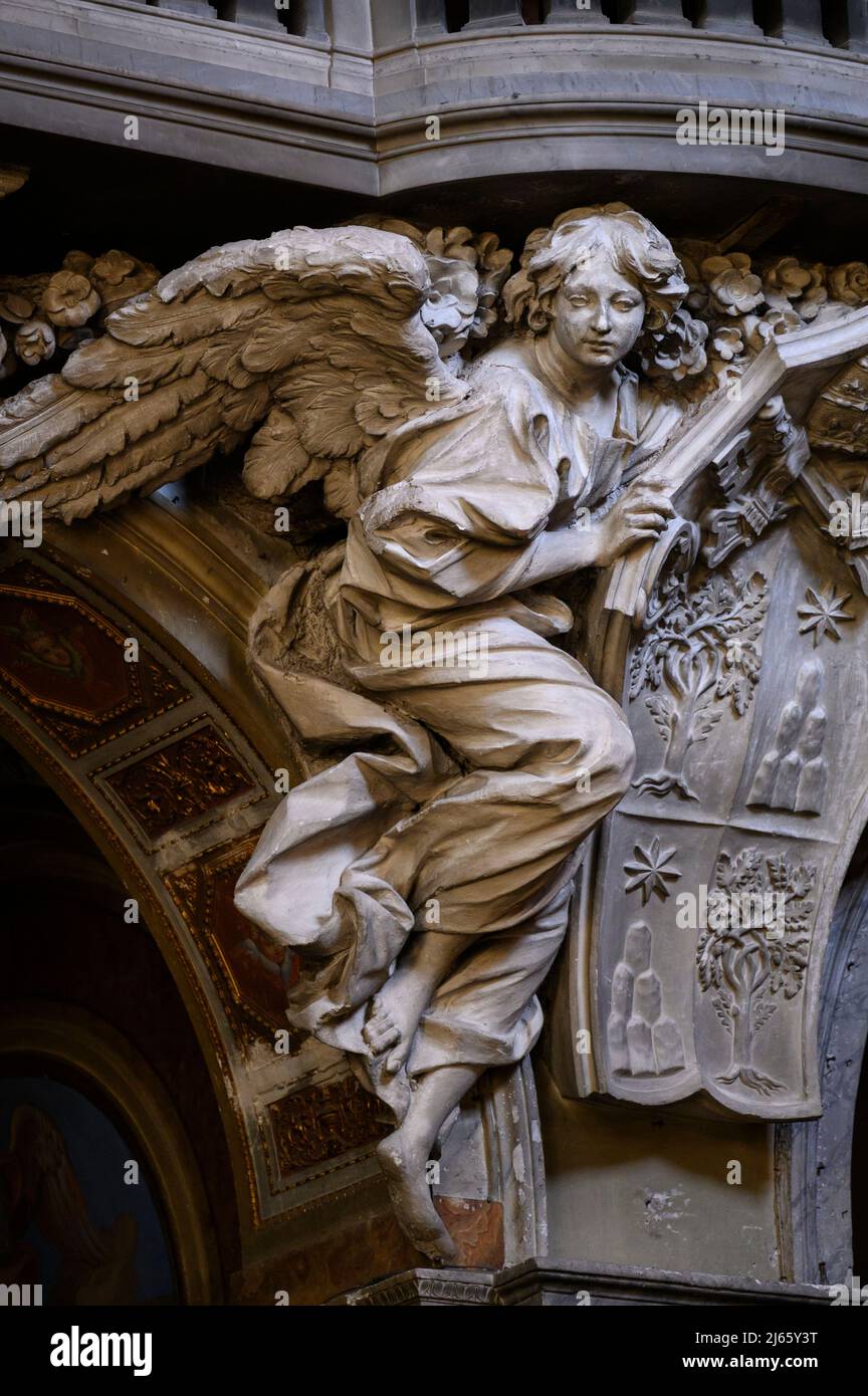 Rome. Italy. Basilica di Santa Maria del Popolo. Cantoria / organ loft, detail showing an angel supporting the coat of arms of Pope Alexander VII.  Ca Stock Photo