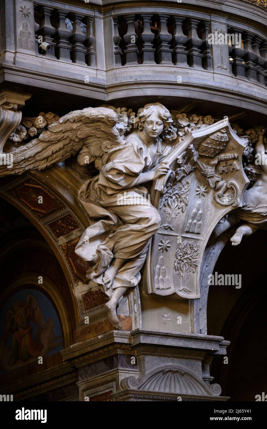 Rome. Italy. Basilica di Santa Maria del Popolo. Cantoria / organ loft, detail showing an angel supporting the coat of arms of Pope Alexander VII.  Ca Stock Photo