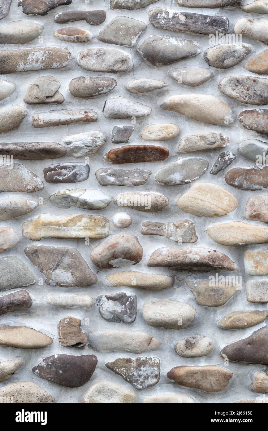 Rock wall of natural river stones. Wall round rock texture and seamless background, pavement Stock Photo