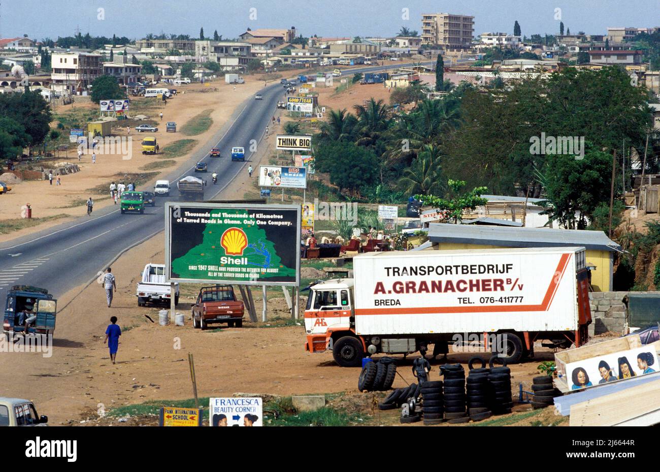 Ghana, Accra; road in Accra with shell billboard and secondhand car