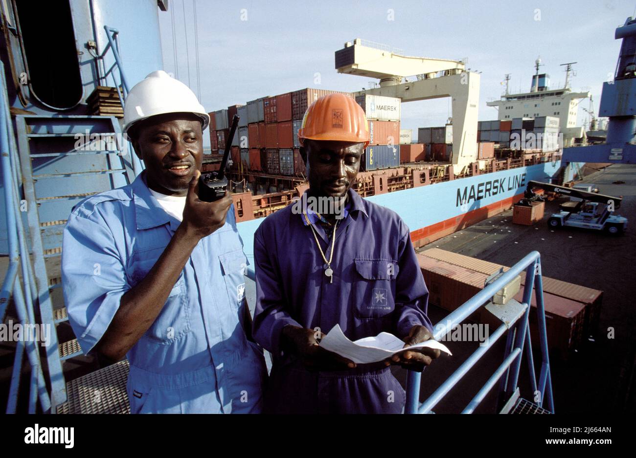 Ghana, Teema; two men in the harbour with container ship Stock Photo
