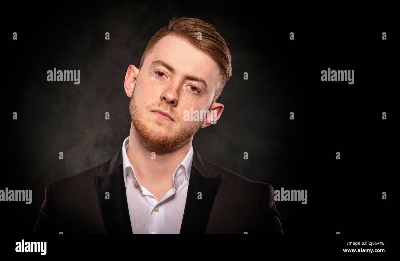 Handsome man in black suit on dark background Stock Photo - Alamy