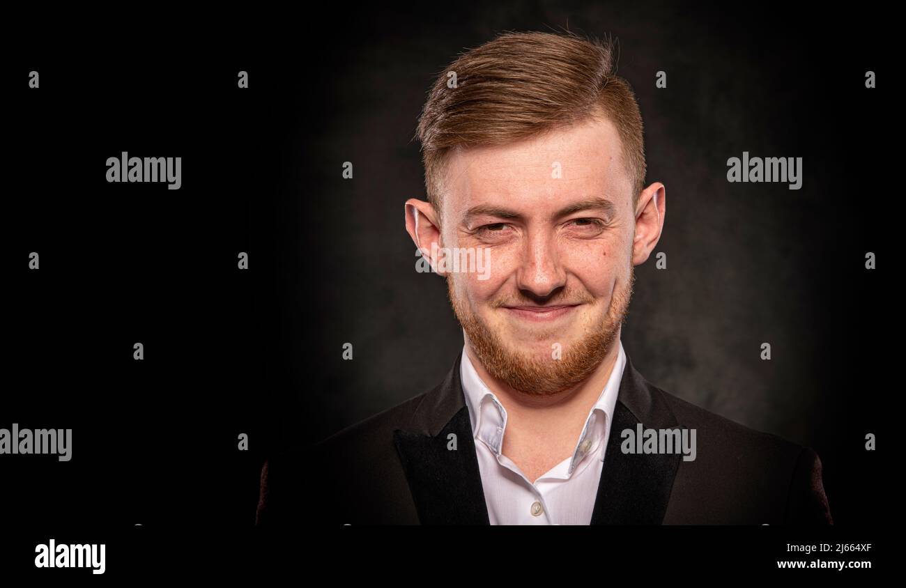 Handsome man in black suit on dark background Stock Photo - Alamy