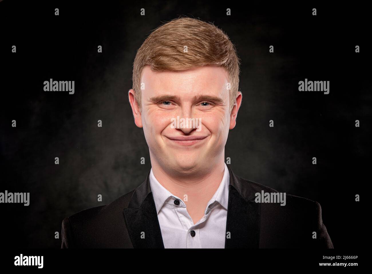 Handsome man in black suit on dark background Stock Photo - Alamy