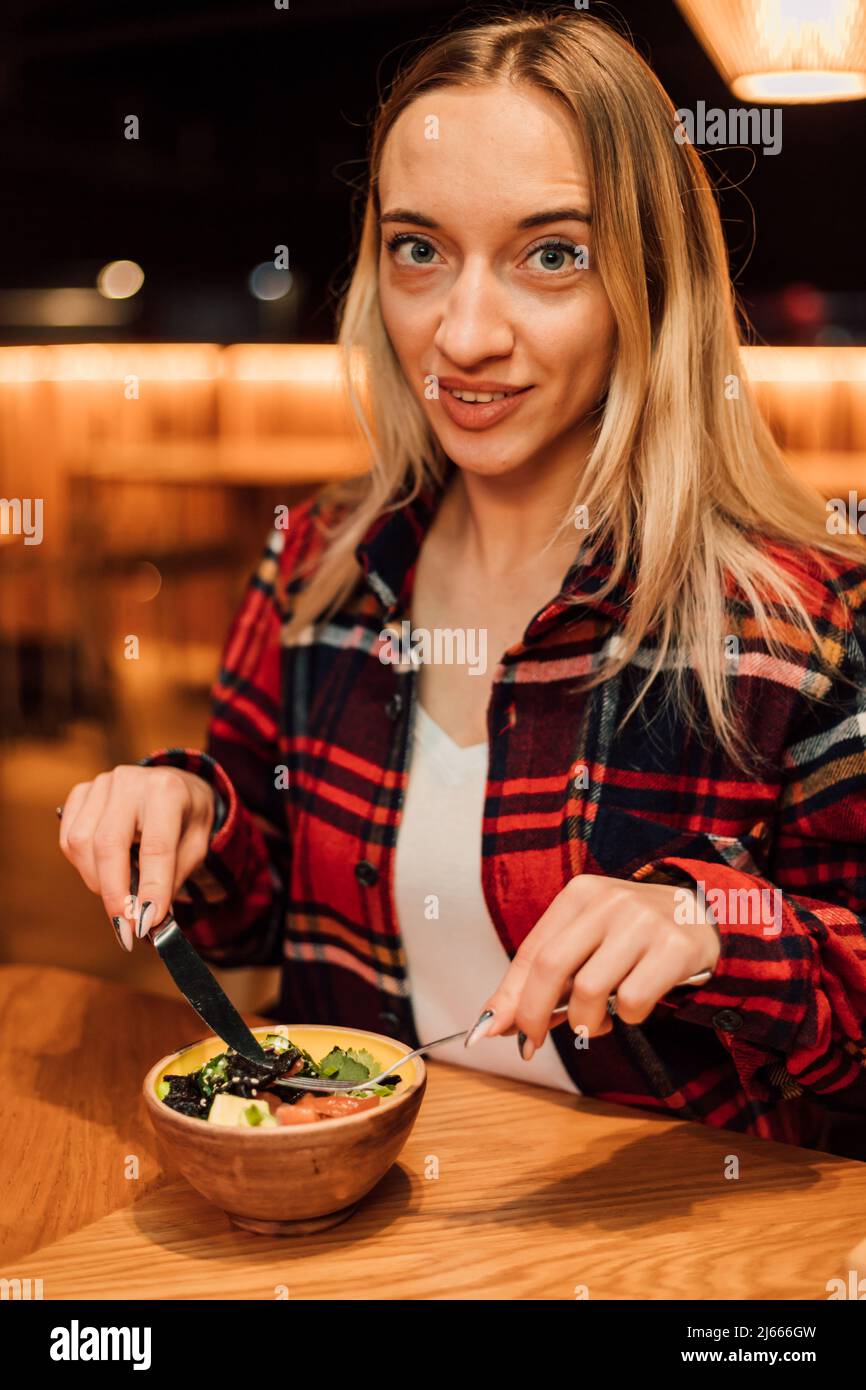 A young girl is going to eat a salad in a restaurant with a fork and knife Stock Photo Alamy
