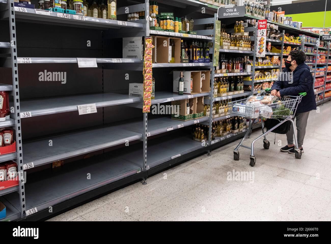 28 April 2022. London, UK.   A customer shops in the empty cooking oil section of a supermarket. Supplies of cooking oil continue to be in short supply due to the war in Ukraine. Photo by Ray Tang Stock Photo