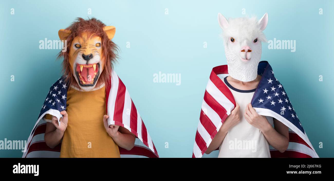 Young woman in lion and alpaca mask hold USA US United States flag wrapped around the shoulders, isolated on blue background Stock Photo