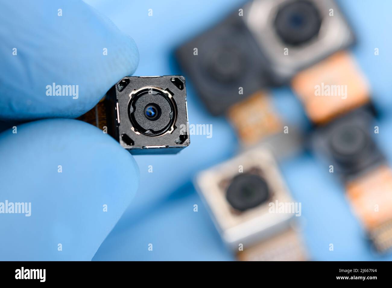 Smartphone camera module in researcher hand, with other cell phone ...
