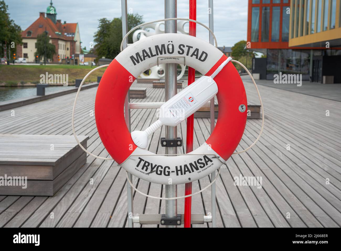 A Trygg-Hansa lifebelt at Gamla staden, Fiskehamnsgatan, Malmo stad. One red and white lifebuoy a symbol for the insurance Stock Photo