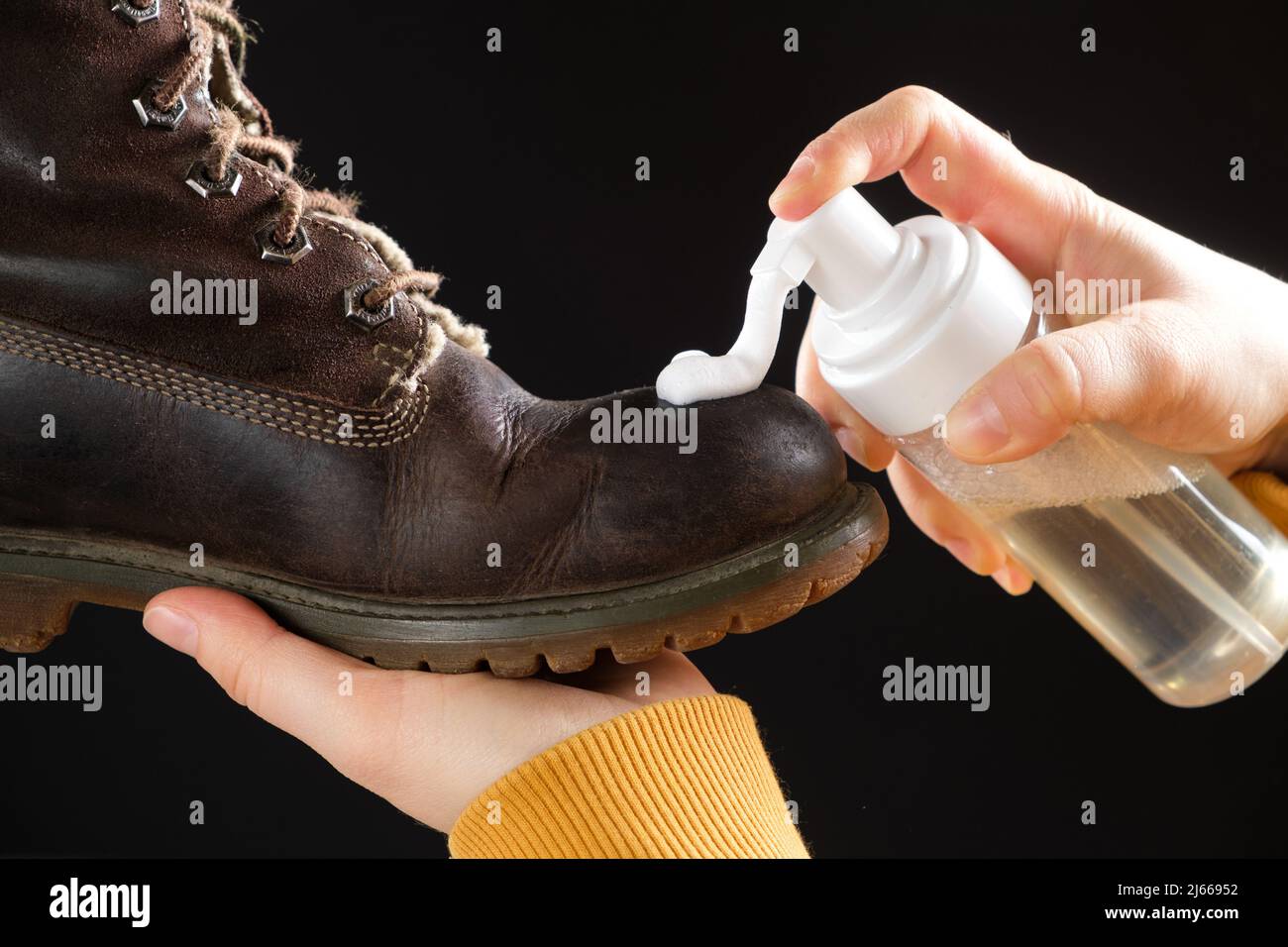 The process of applying cleansing foam to brown women's nubuck shoes on