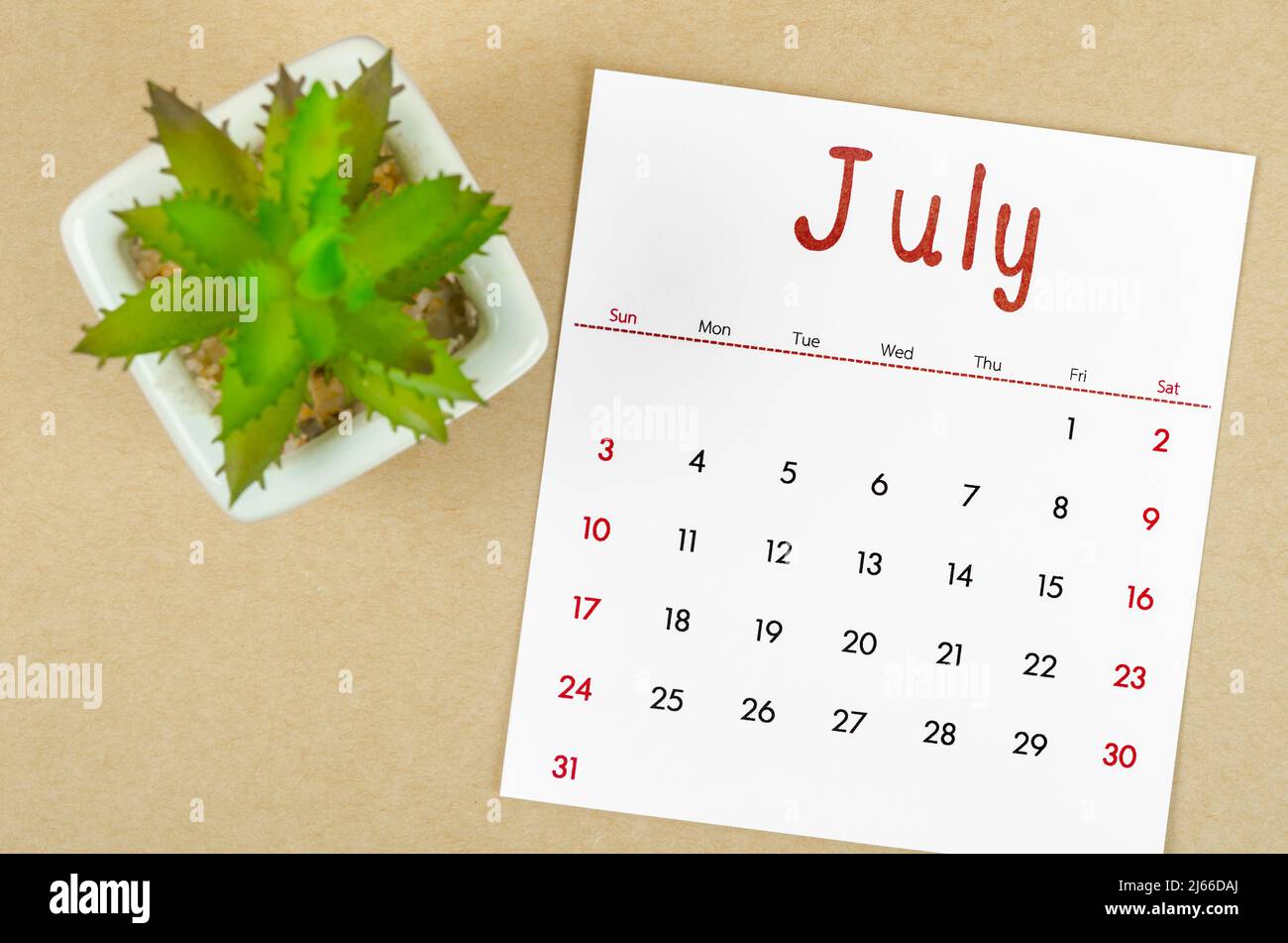 The July 2022 calendar with plant pot on brown paper background Stock