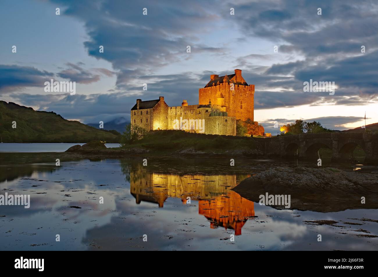 Das angestrahlte Castle Eilean Donan spiegelt sich im Wasser des Loch, blaue Stunde, Filmkulisse, Dornie, Highlands, Schottland, Grossbritannien Stock Photo