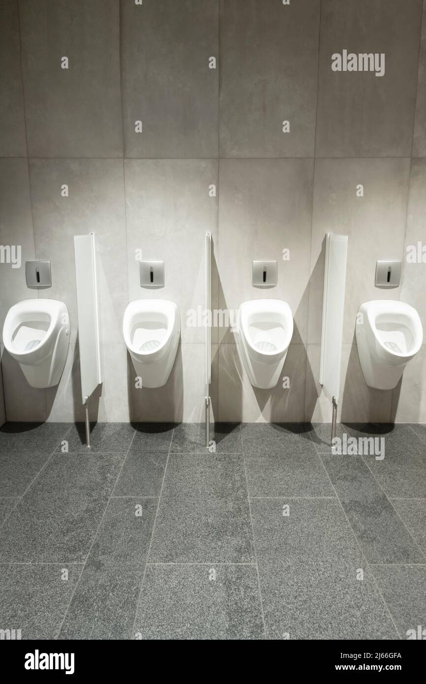 Row of urinal toilet blocks in men public toilet or restroom Stock