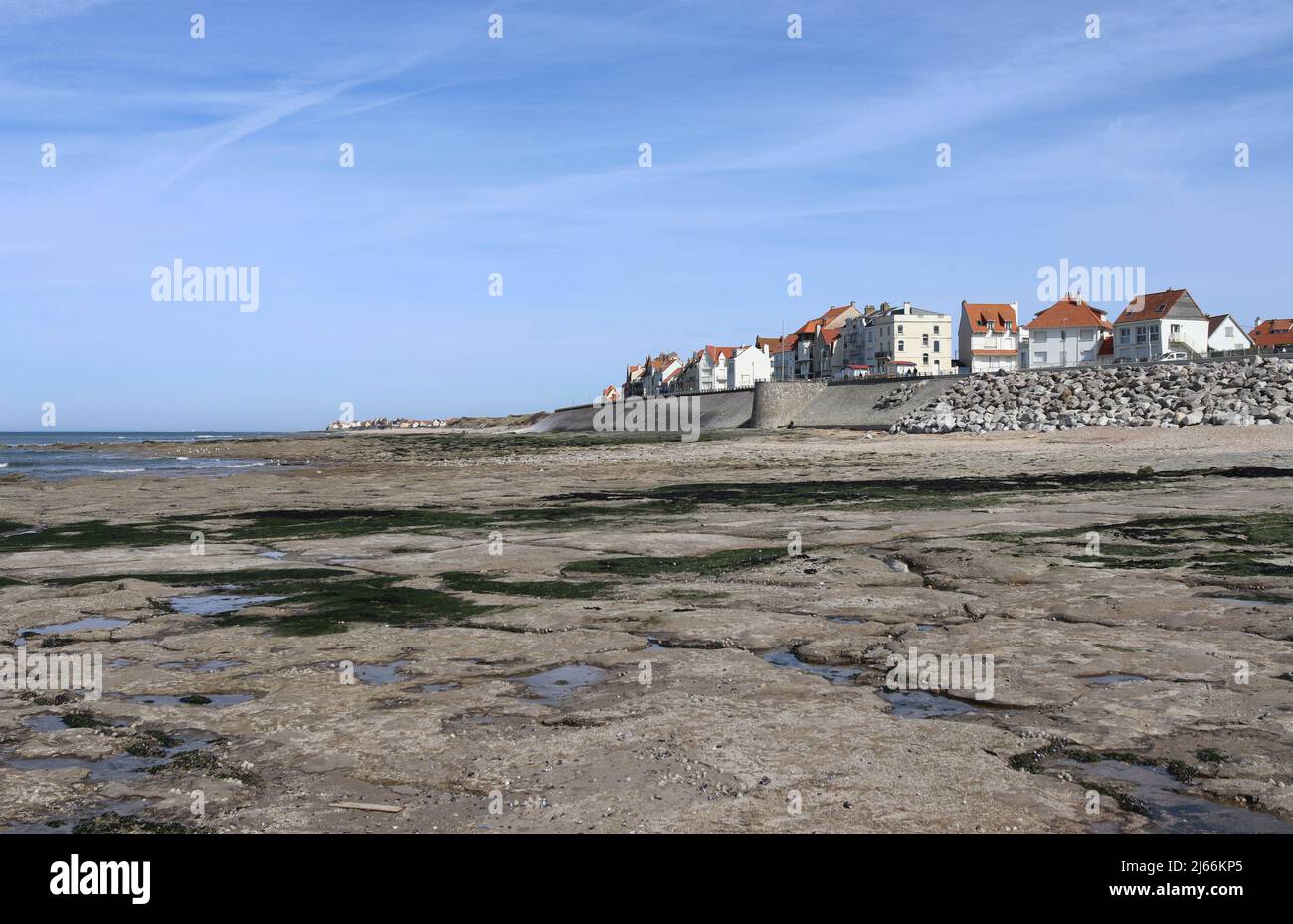 View of the resort town of Ambleteuse, from the beach on the beautiful Opal Coast of Northern France. Sunny spring day, with low tide and blue sky. Stock Photo
