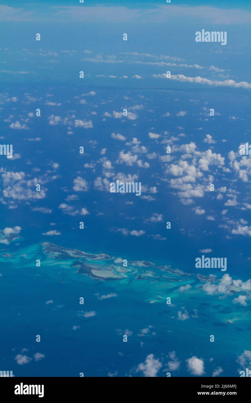High aerial view of clouds over the Caribbean Sea and islands of the tropics from a commercial airliner Stock Photo