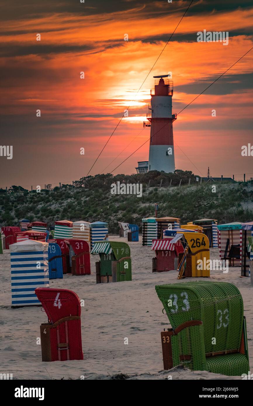 Impressionen von der Insel Borkum - Strandkörbe am Südstrand, Sonnenuntergang mit Abendrot, Elektrischer Leuchtturm Borkum. Stock Photo