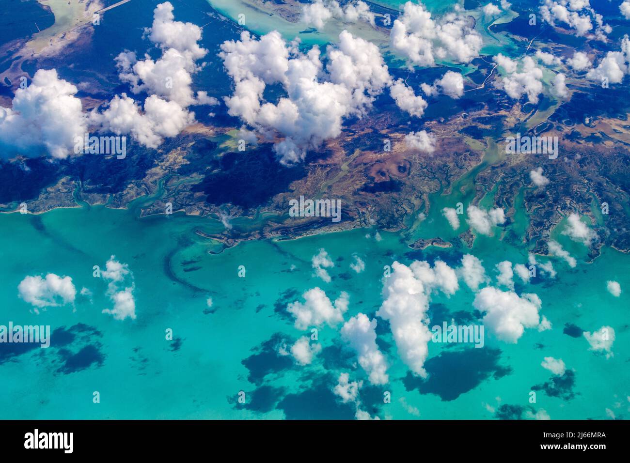 High aerial view of clouds over the Caribbean Sea and islands of the tropics from a commercial airliner Stock Photo