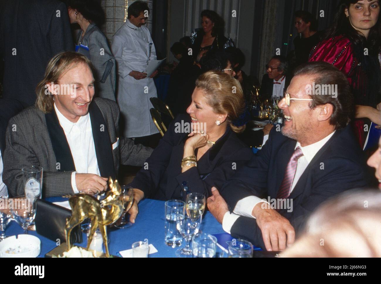 Otto Waalkes, deutscher Komiker und Schauspieler, mit Schauspieler Roger Moore und dessen dritter Ehefrau Luisa, Deutschland um1989. Stock Photo