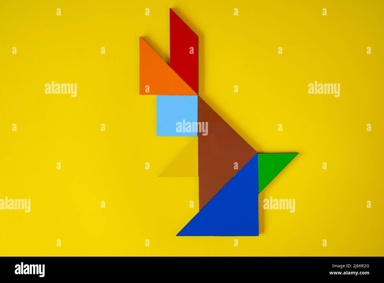Tangram rabbit, top view of tangram animal rabbit, lay down, isolated on yellow background, colorful tangram puzzle toy concept Stock Photo