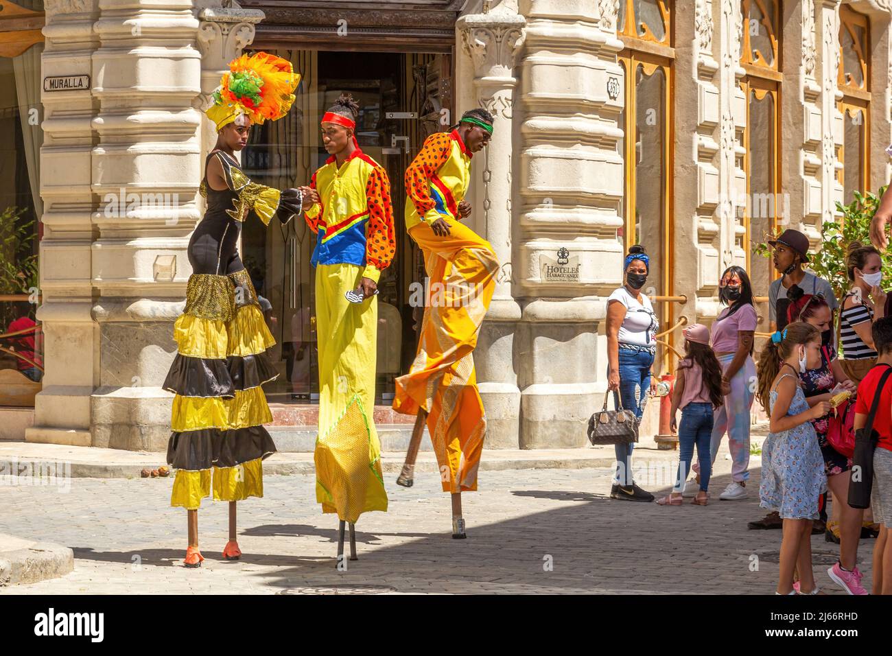 Conga dancers in stilts performing in Old Havana. They are wearing colorful traditional clothing. Stock Photo