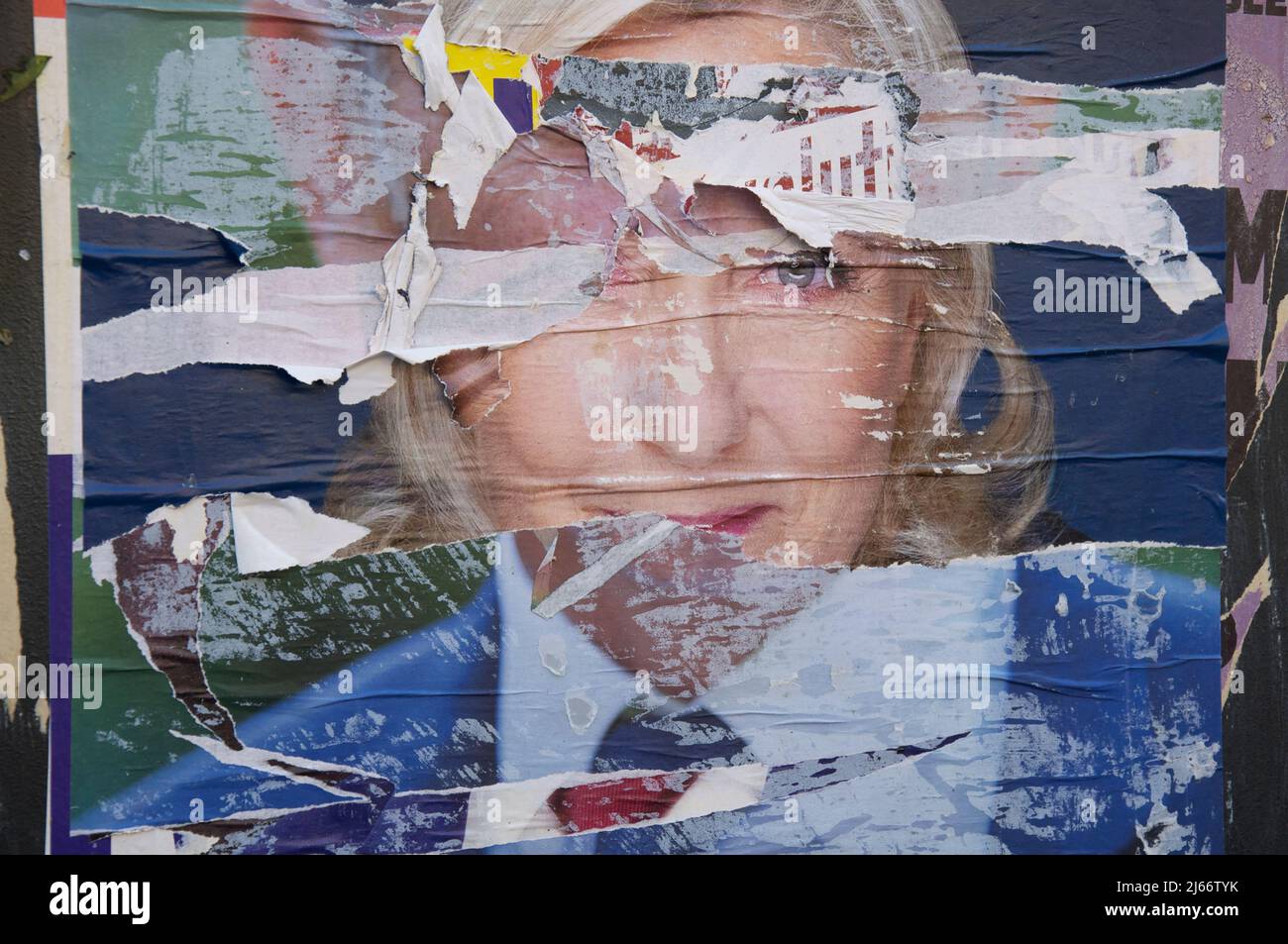 French Presidential Election 2022. Layers of torn campaign posters ripped to reveal the face of the populist right wing candidate Marine Le Pen. Paris. Stock Photo