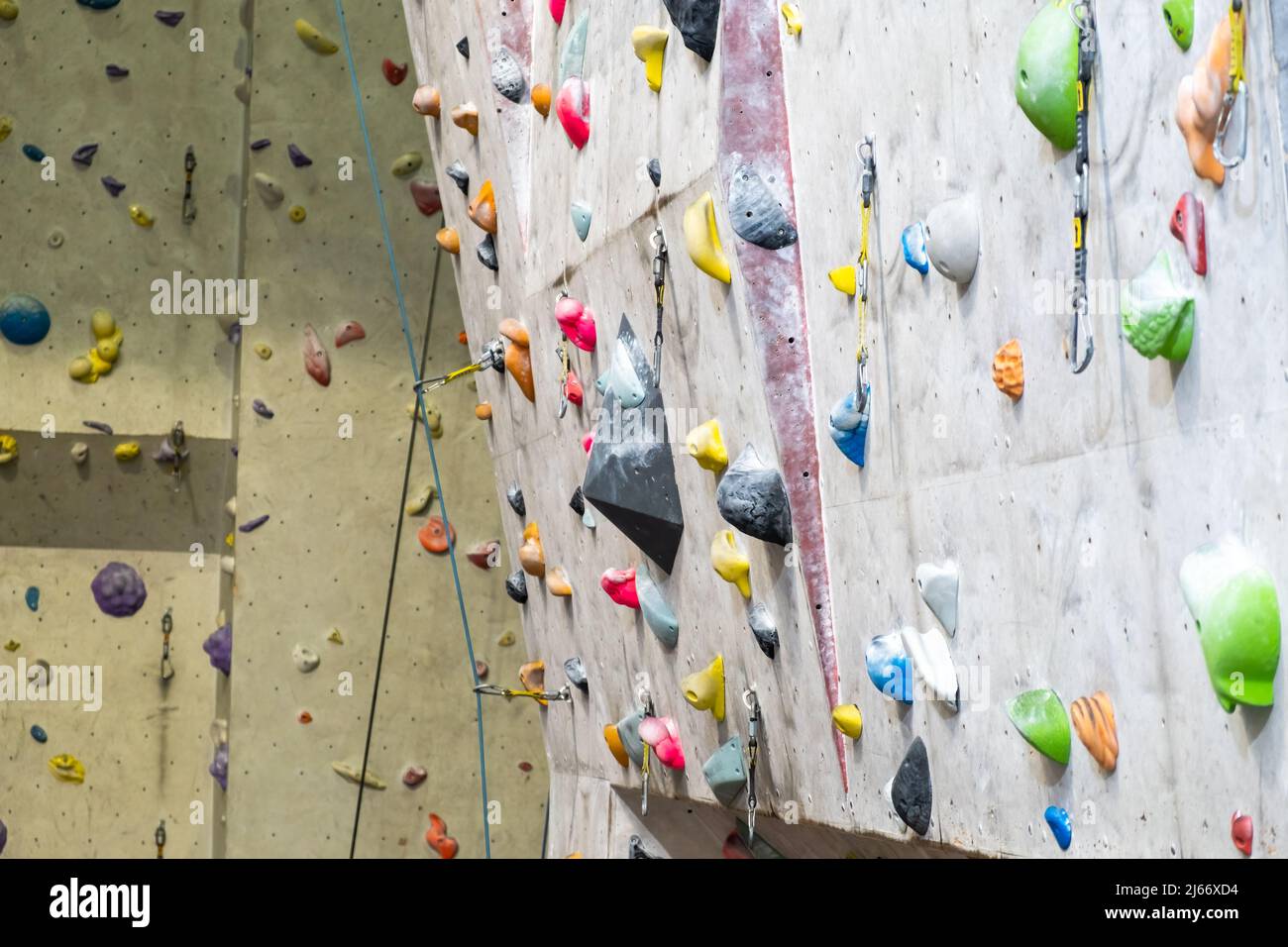 Artificial rock climbing wall with various colored grips Stock Photo