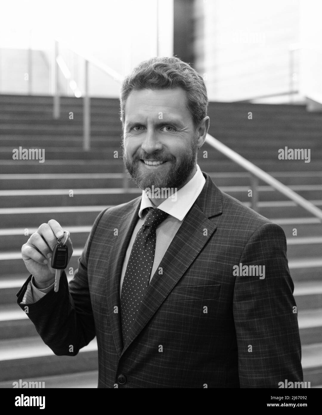 happy bearded man businessman in suit hold car or house keys, real estate Stock Photo