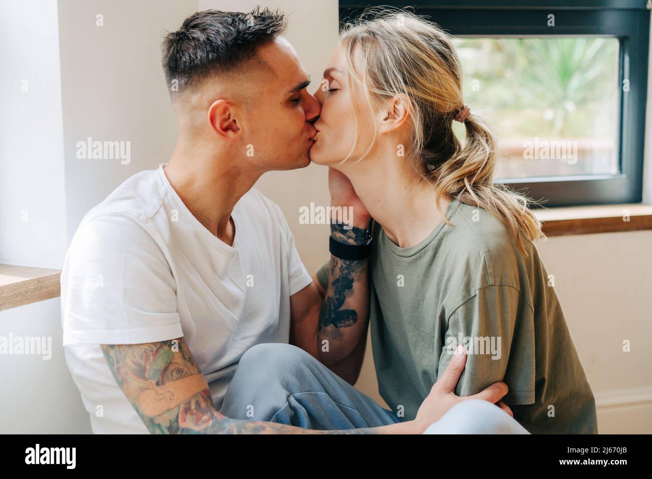 young man and woman hugging and kissing at the sunset Stock Photo. 