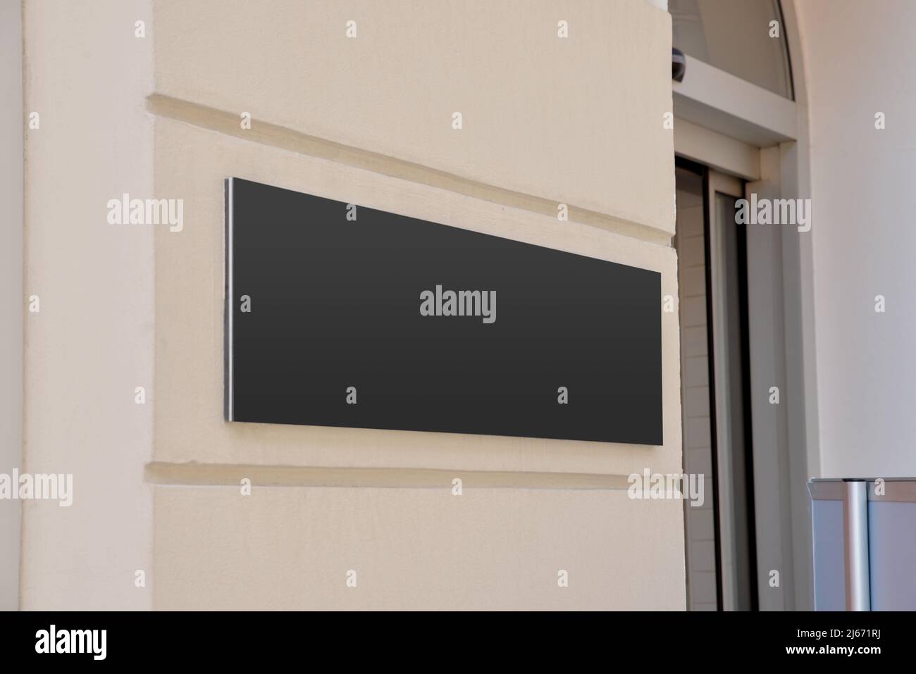 Black signboard at the entrance to the company's building. Clean surface for company logo presentation Stock Photo