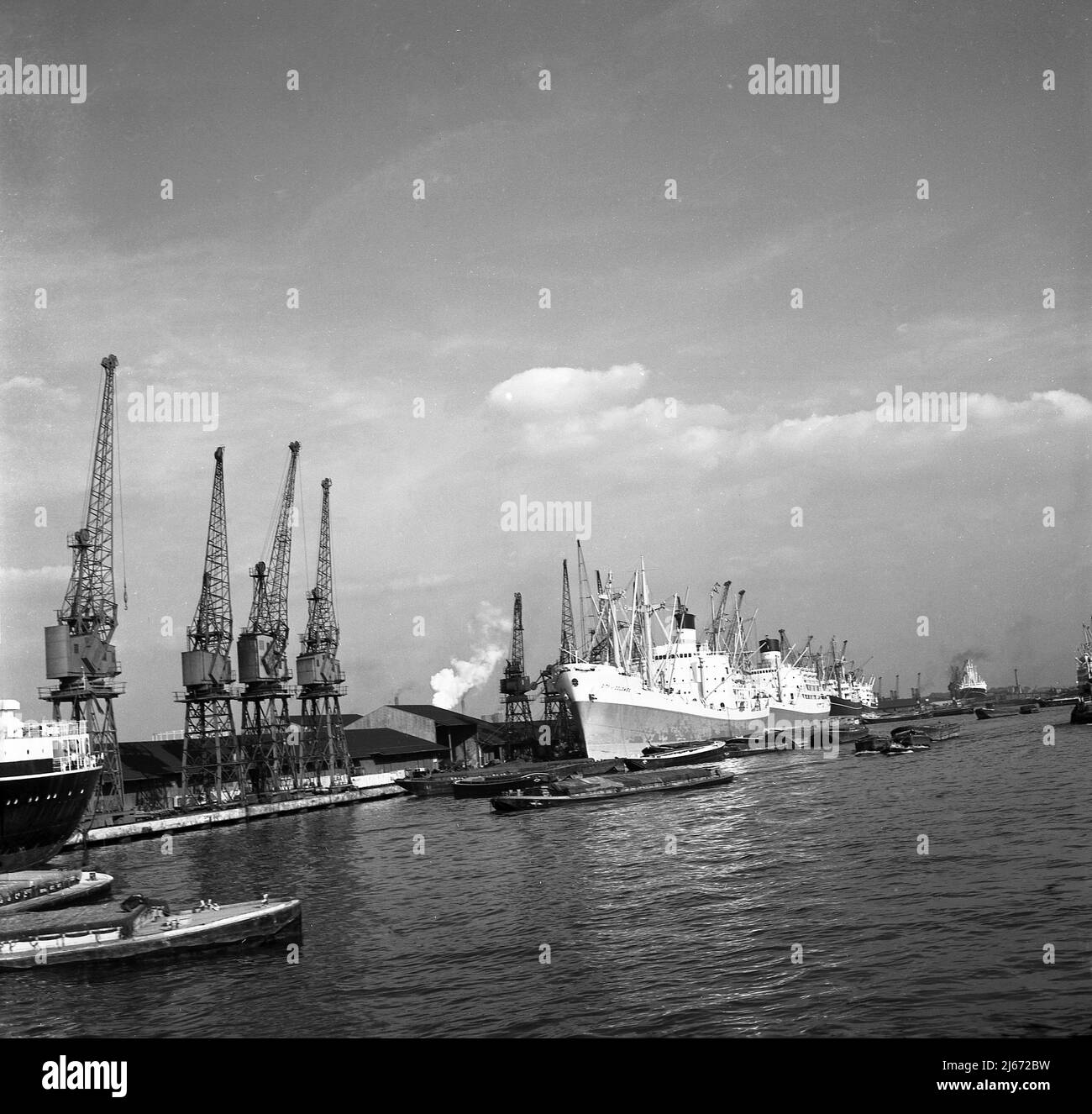 1960s, historcial, Port of London, large steam drived cargo ships moored up beside the dockside cranes, East London docks, England, UK. Stock Photo