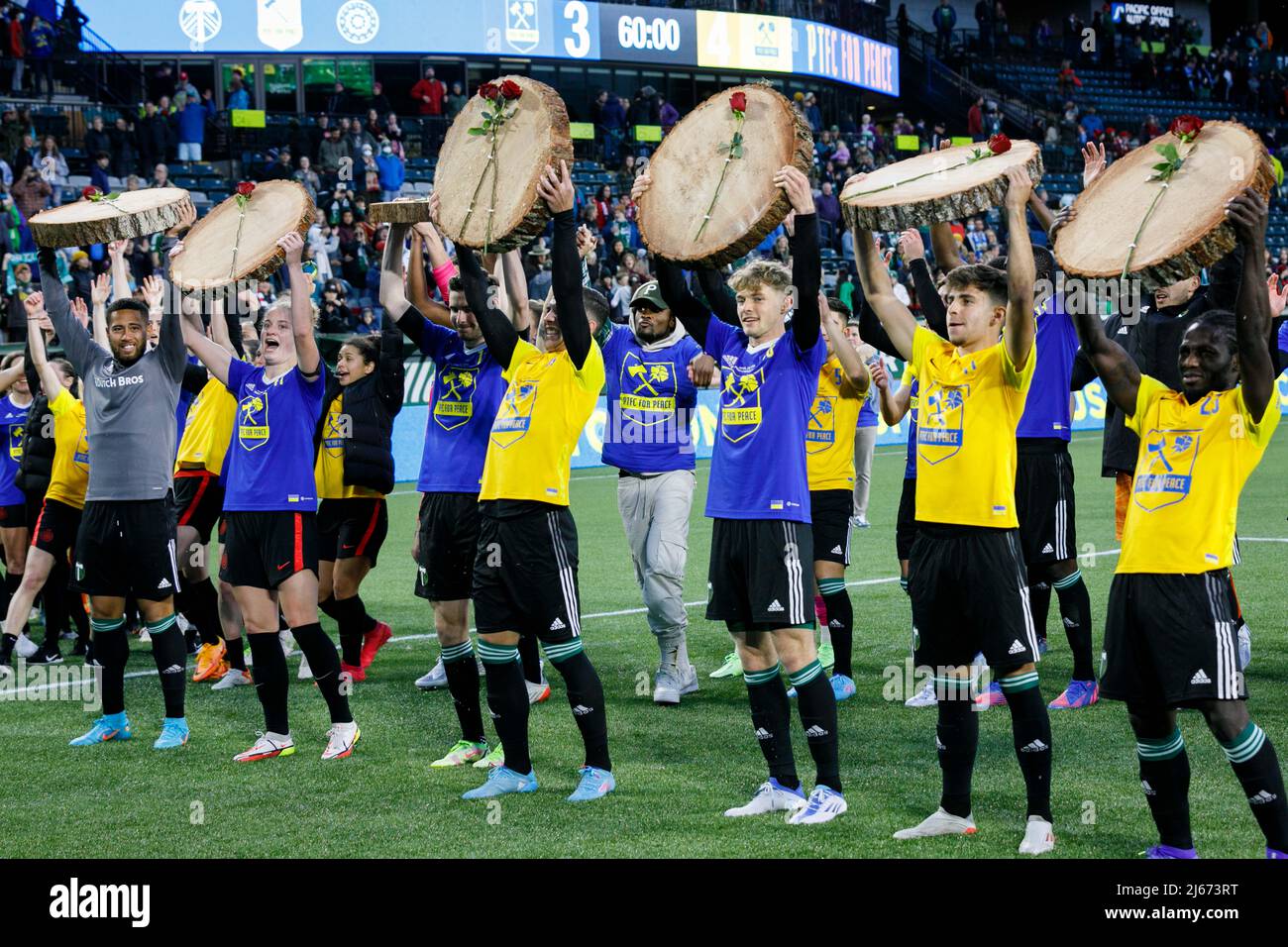 The scoring players lift their sections of tree trunk. The Portland