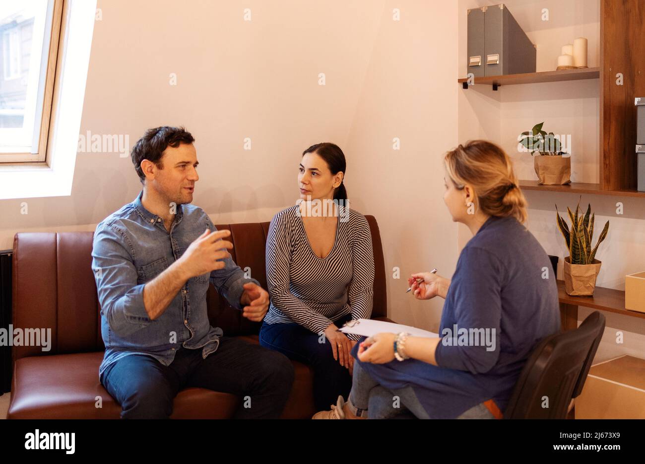 Couple therapy. Nice serious couple visiting a psychologist and having a psychological session while dealing with problems in relationships together Stock Photo