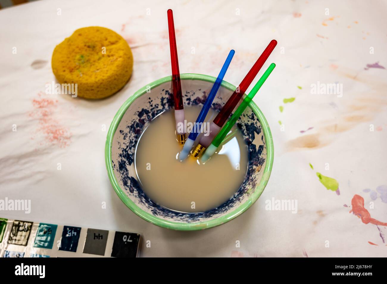 Selection of paint brushes in a bowl of dirty water from an art project
