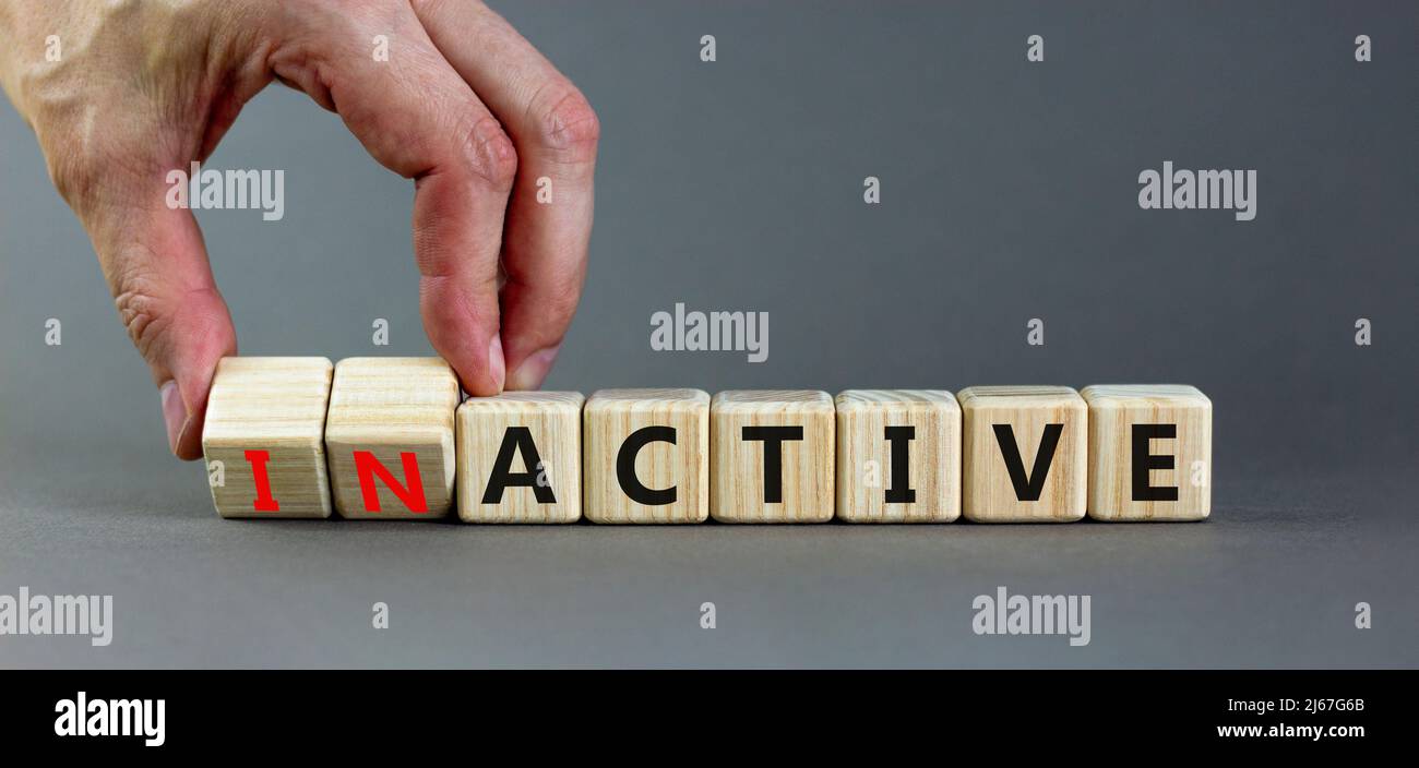 Active or inactive symbol. Businessman turns wooden cubes and changes