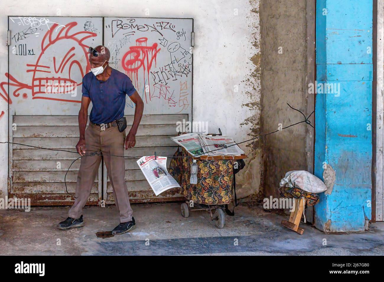 An Afro-Caribbean Cuban man sells the Granma newspaper in the capital city. Granma is the official printed media of the Communist Party of Cuba. Stock Photo