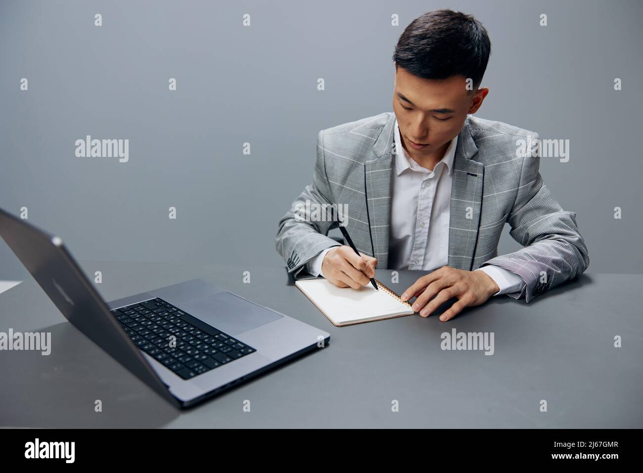 worker writing in a notebook laptop work at the desktop isolated ...