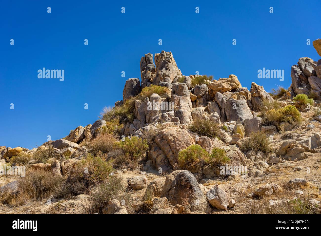 Low angel view of a hill with boulders and rocks in the Mojave Desert Stock Photo