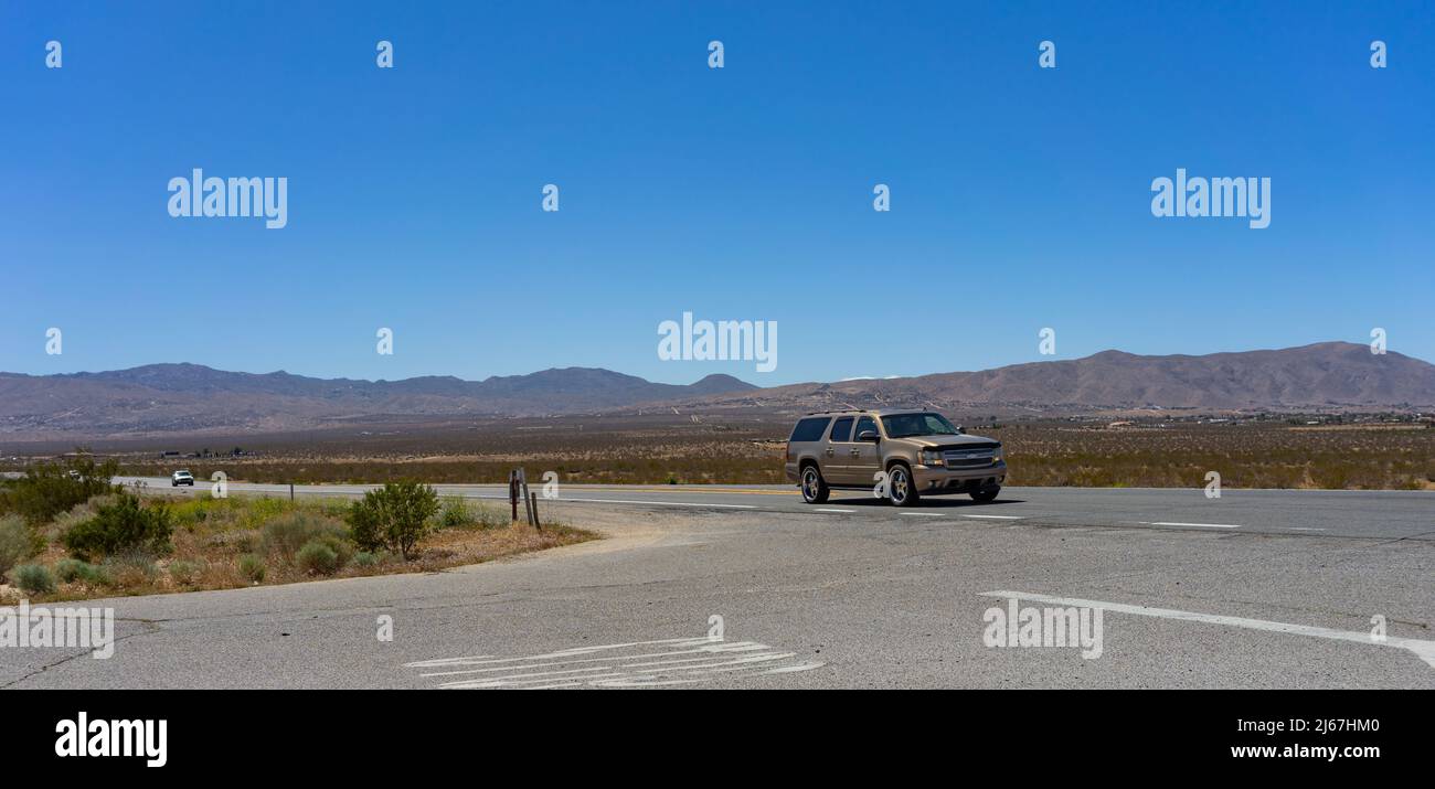 Apple Valley, CA, USA – April 20, 2022: A SUV truck traveling on State Route 18 in the Mojave Desert in Apple Valley, California. Stock Photo