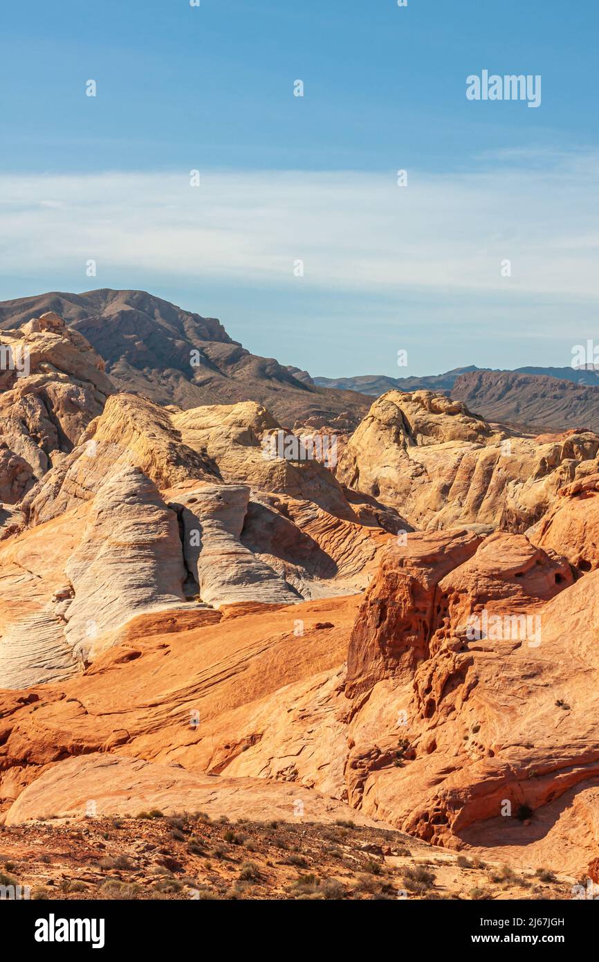 Overton, Nevada, USA - February 24, 2010: Valley of Fire. Portrait landscape of beige, orange, and red rounded tops of mountains under light blue clou Stock Photo