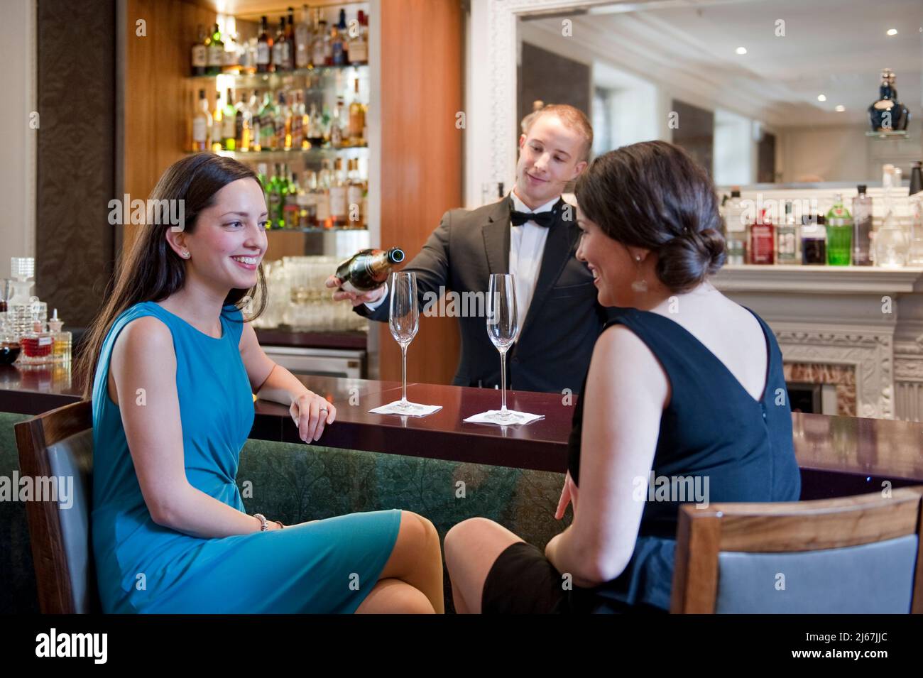 Your women talking at the bar counter with bartender serving cocktail. Stock Photo